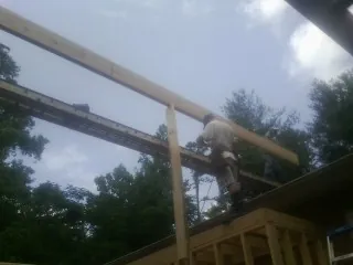 Carpenter setting a ridge beam over a new addition frame — Ice Dam Removal by Roofing Brothers in Laurel Bloomery