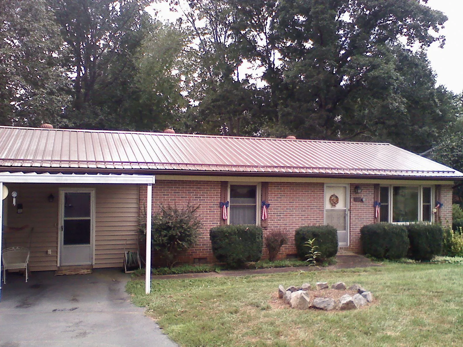 Bronze metal roof and carport on a brick ranch home — Roof Repair work by our crew in Laurel Bloomery